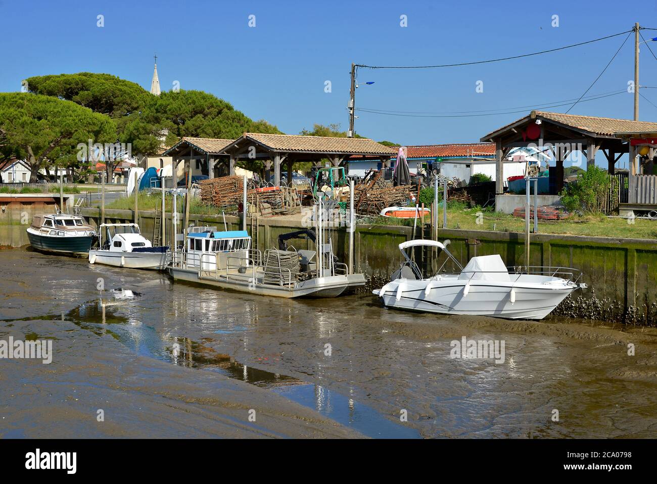 Bateaux et barges dans le port ostreicole à marée basse d'Audenge, commune est un situé sur la rive nord-est de la baie d'Arcachon, dans le département de Gironde Banque D'Images