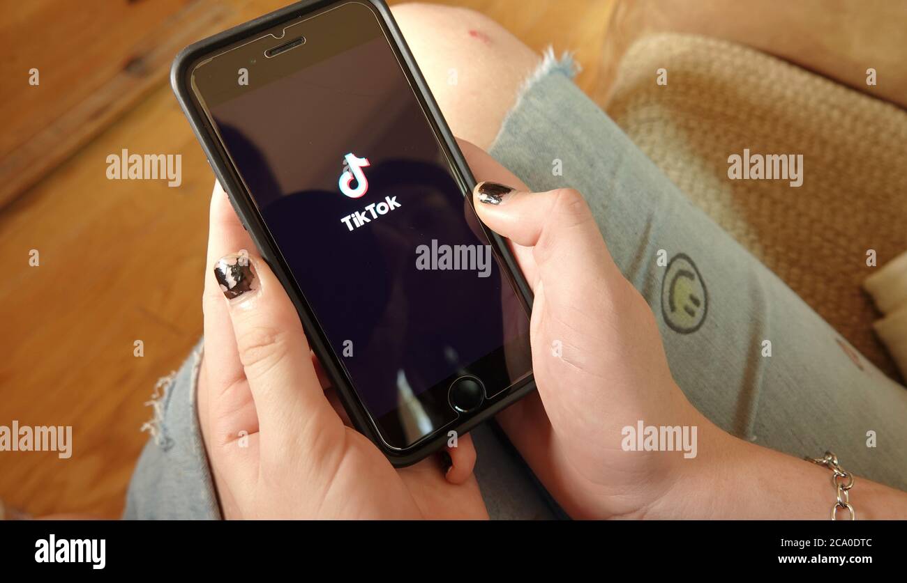 Gros plan d'un smartphone dans la main d'une fille, ouvrant l'application TikTok. Éditorial illustratif pris dans Vista, CA / USA le 2 août 2020. Banque D'Images