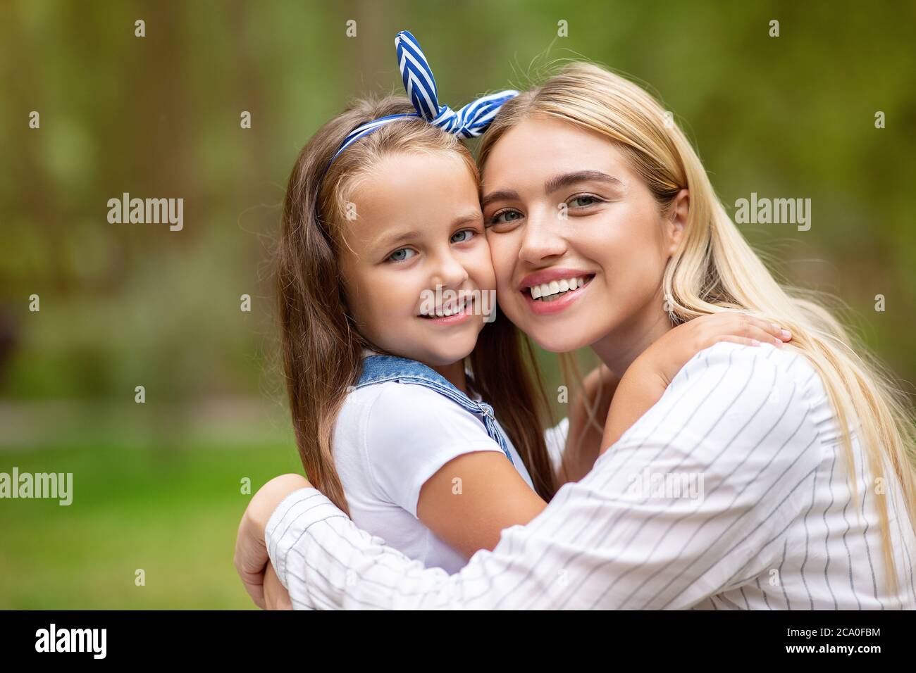 Bonne maman et fille souriant à Camera in Park Banque D'Images