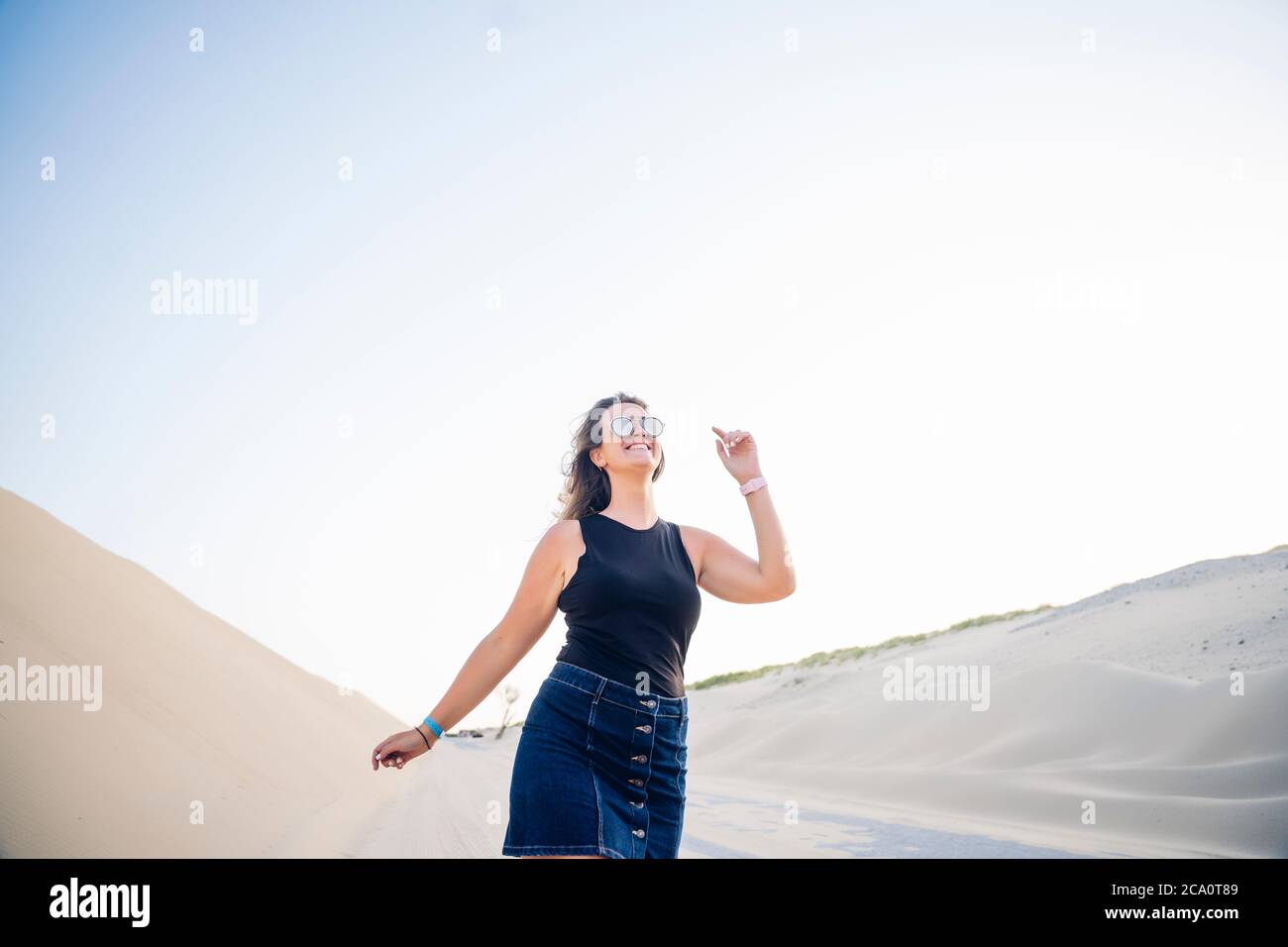 Jeune femme marchant le long des dunes Banque D'Images