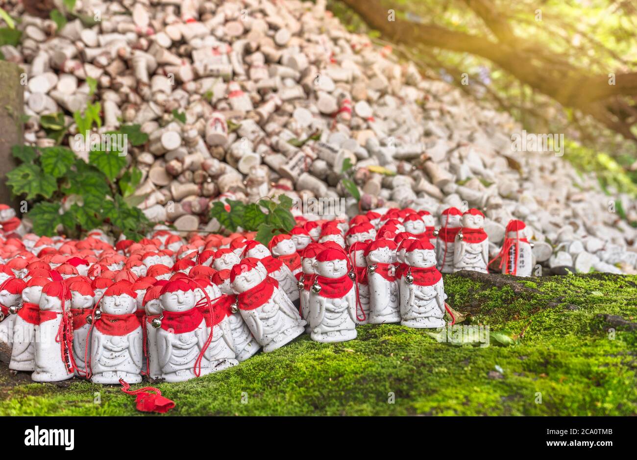 Des milliers d'amulettes de gardien bouddhiste divinité de l'enfer Jizō bossatsu portant une casquette et un bavoir rouge pour les enfants décédés déposés par les adorateurs sur le Banque D'Images