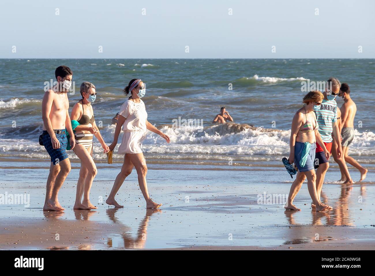 Punta Umbria, Huelva, Espagne - 2 août 2020: Personnes marchant sur la plage portant des masques protecteurs ou médicaux. Nouvelle normale en Espagne avec di social Banque D'Images