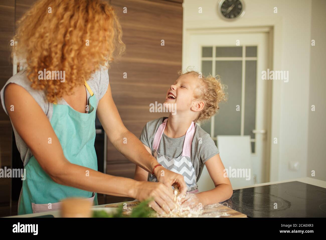 Joyeux cacaucasien maman et fille préparant la boulangerie ensemble, la cuisine de pizza et de s'amuser dans la cuisine. Couple aimant embrassant, embrassant avec ha Banque D'Images
