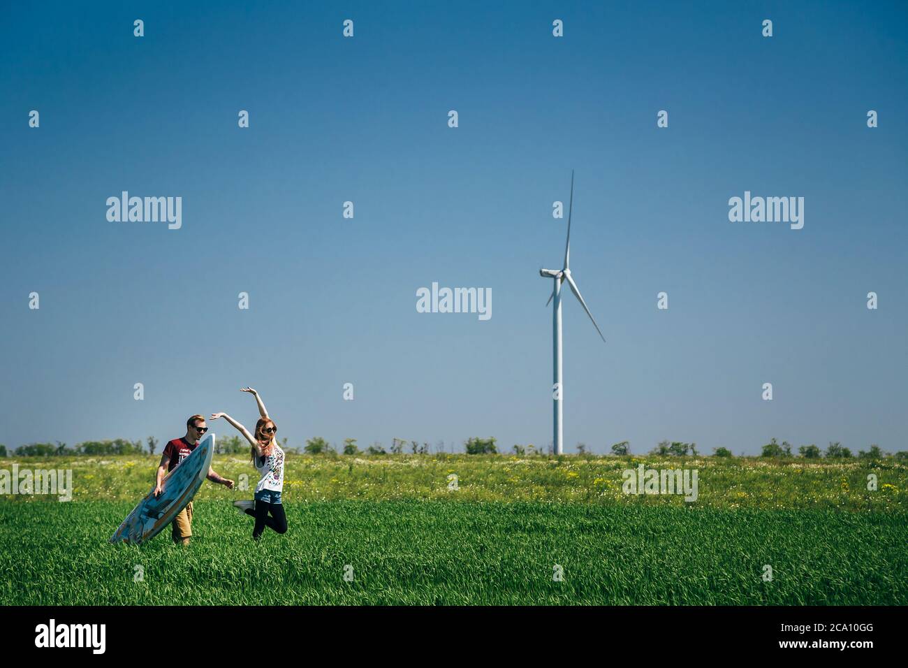 ODESSA, UKRAINE - MAI, 20 2015: Mignon jeune hipster couple de surfeurs avec une planche de surf est sur le chemin de la plage Banque D'Images