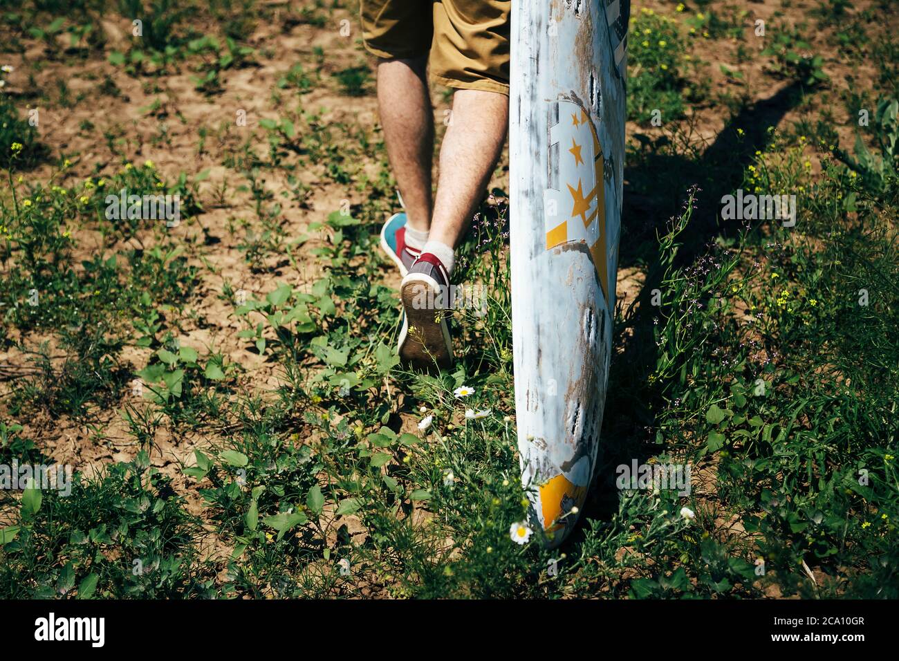 ODESSA, UKRAINE - MAI, 20 2015: Un jeune surfeur avec une vieille planche de surf est sur son chemin à la plage Banque D'Images