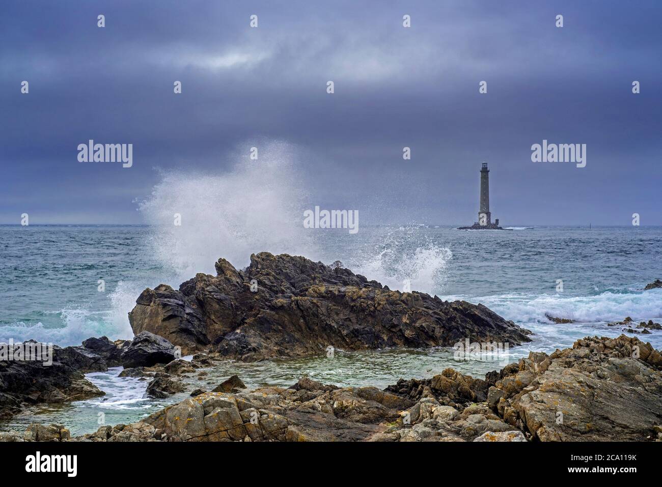 Les vagues s'écrasant sur le rocher et le phare Phare de la Hague / Phare de Goury près d'Auderville, Cap de la Hague, péninsule du Cotentin, Basse-Normandie, France Banque D'Images