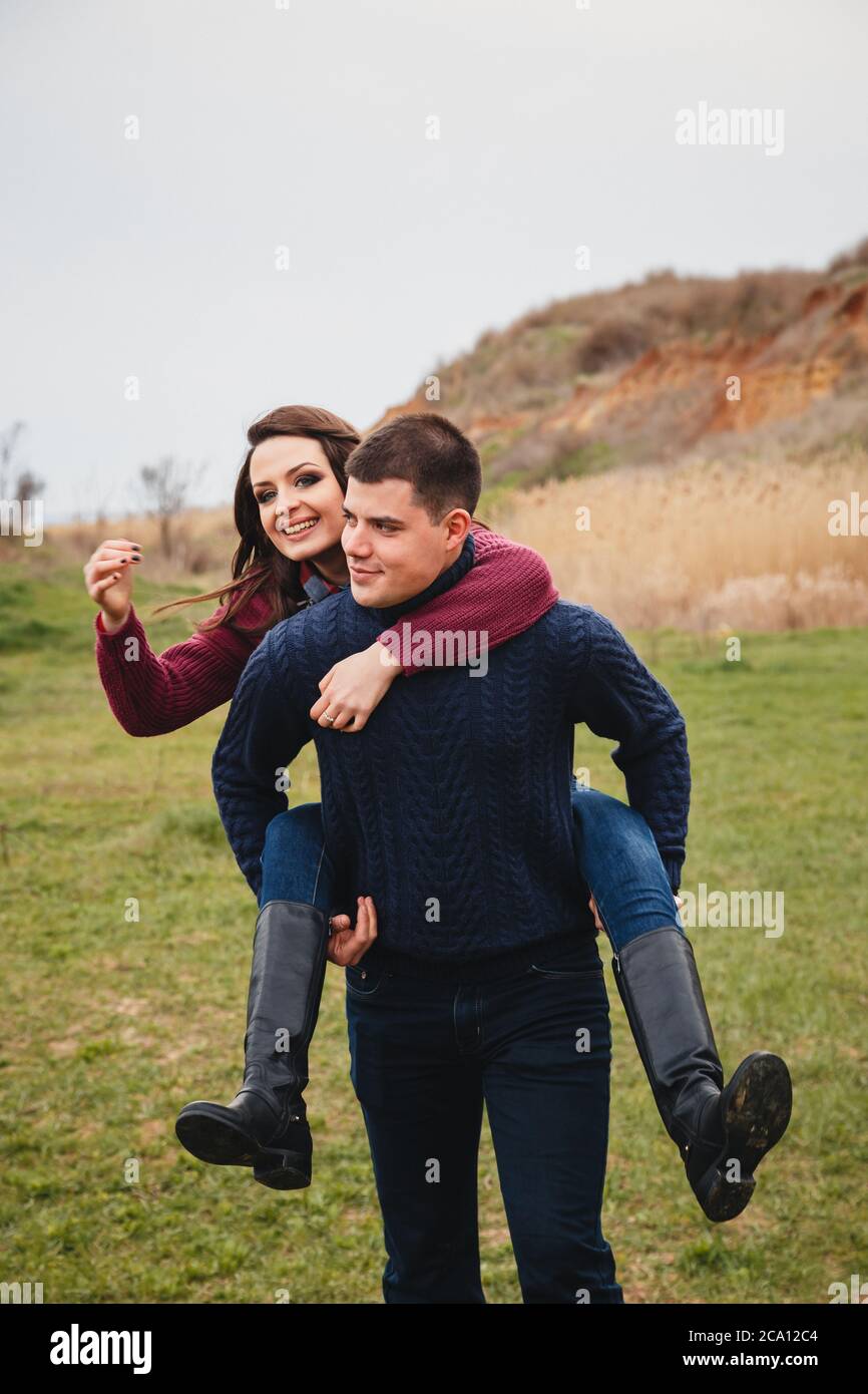 Un jeune couple mignon se moque, en plein milieu d'un champ vert. Bon jour, bonheur, amitié, concept de vacances Banque D'Images