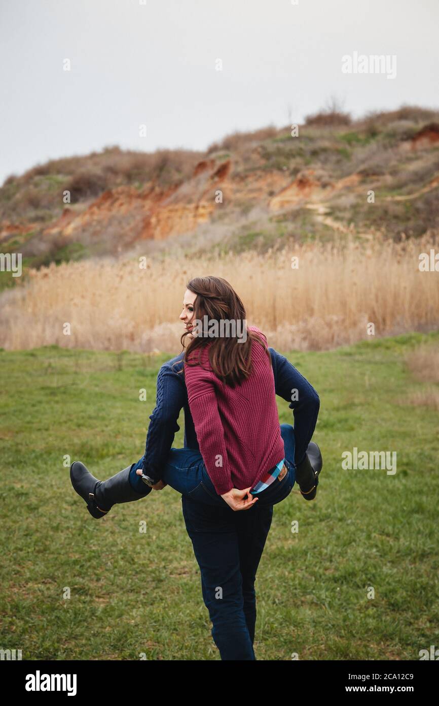 Un jeune couple mignon se moque, en plein milieu d'un champ vert. Bon jour, bonheur, amitié, concept de vacances Banque D'Images