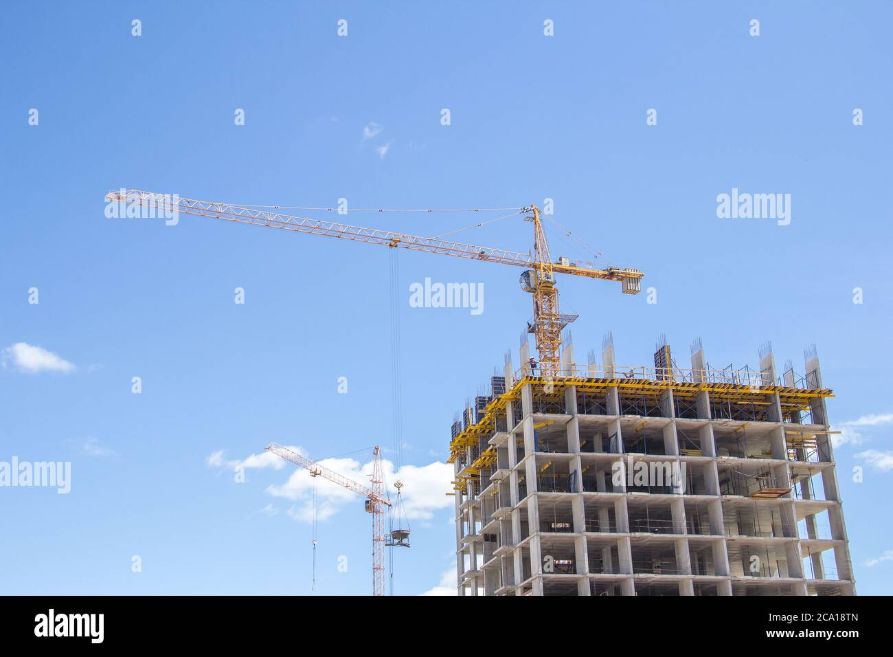 Construction à l'arrière-plan du ciel bleu. Bâtiment résidentiel. Cadre en béton armé du bâtiment. Banque D'Images