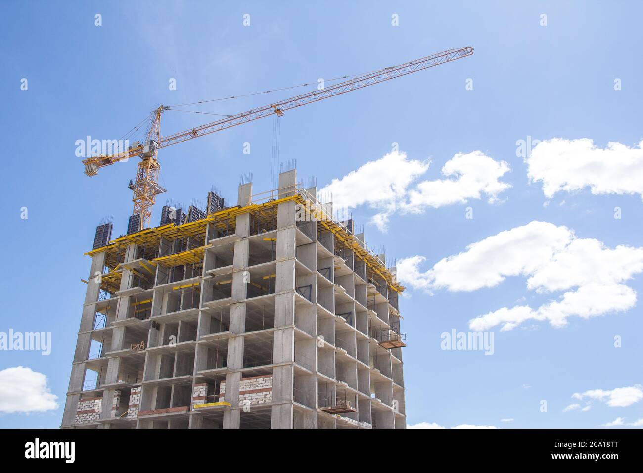 Construction à l'arrière-plan du ciel bleu. Bâtiment résidentiel. Cadre en béton armé du bâtiment. Banque D'Images