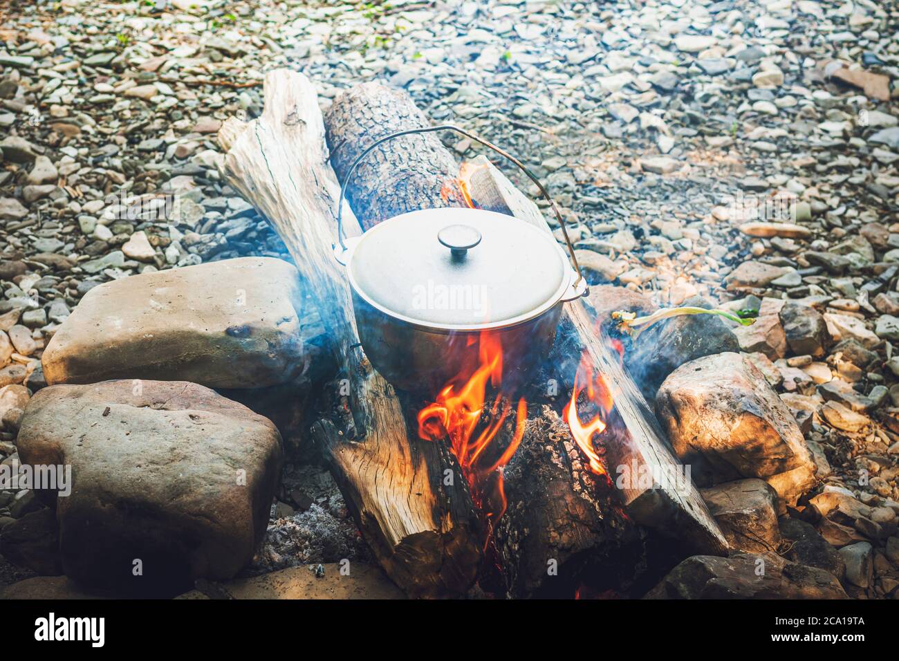 Voyage, tourisme, cuisine pique-nique, cuisine dans un chaudron sur le feu, marmite au feu de camp sur le pique-nique. Banque D'Images
