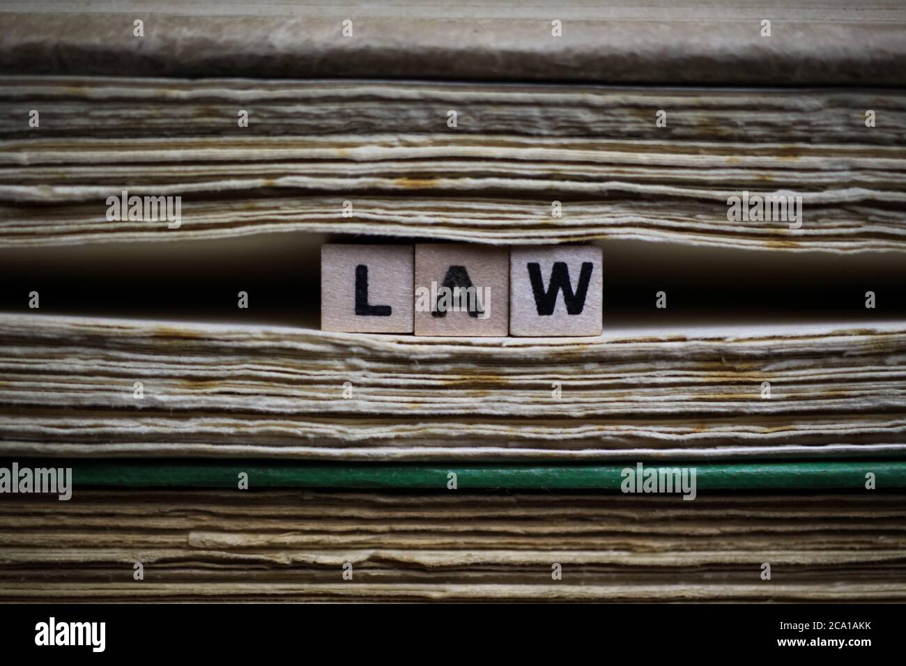 Conditions juridiques cadre concept: Gros plan de blocs de texte anciens isolés de pile de livre ancien et de pages jaunâtées avec des cubes en bois de l'alphabet formant le mot l Banque D'Images