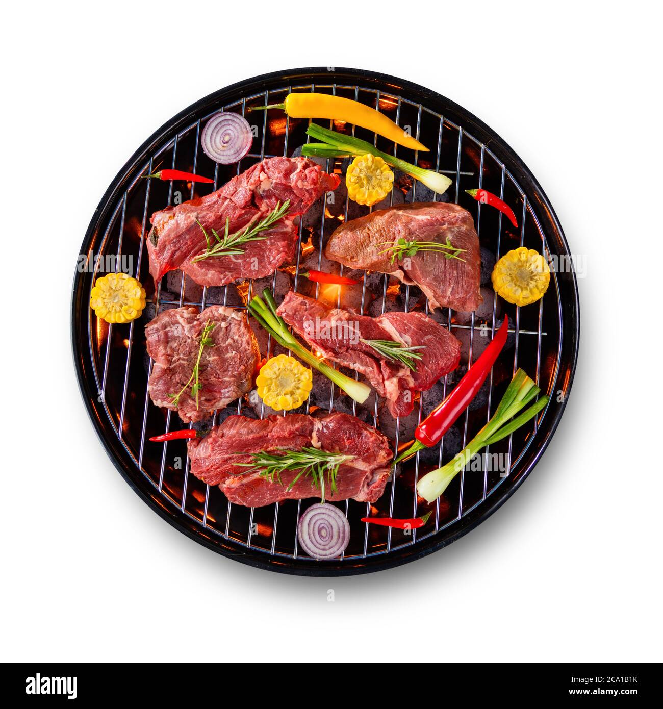 Steaks de bœuf frais crus avec légumes placés sur le gril, isolés sur fond blanc. Cuisson, préparation et barbecue d'objets. Banque D'Images