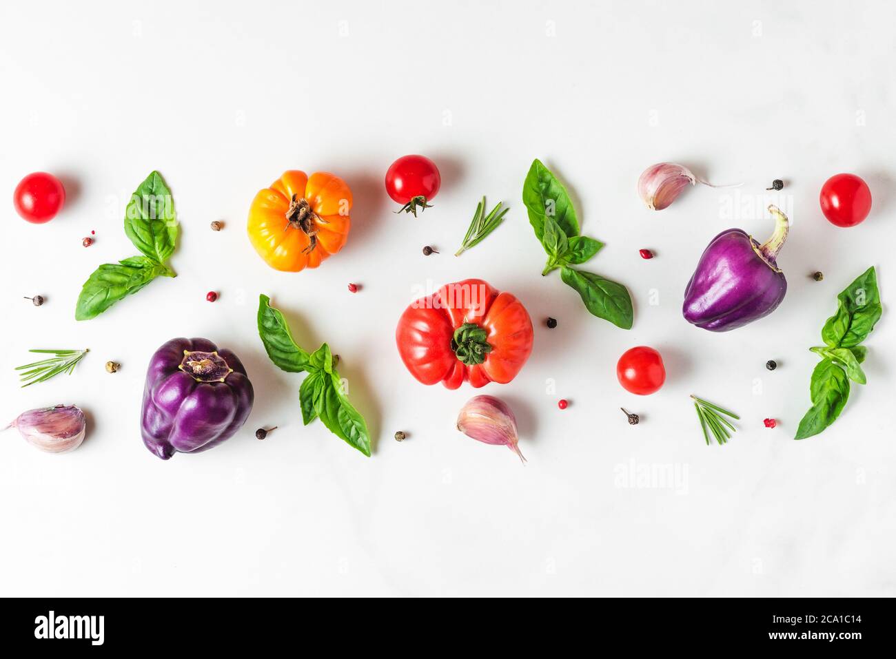 Légumes biologiques colorés. Tomates, poivre, ail et basilic sur fond blanc. Composition des aliments. Vue du dessus. plat Banque D'Images
