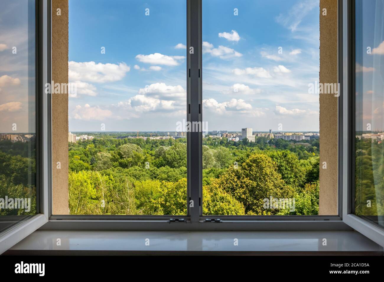 Vue depuis la fenêtre ouverte sur le paysage urbain d'été Banque D'Images
