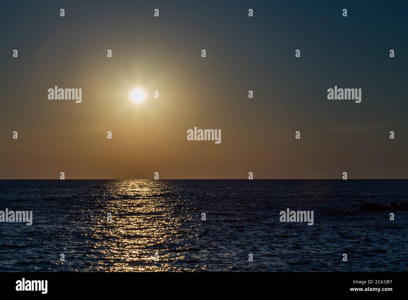 le soleil brille sur les vagues au coucher du soleil Banque D'Images