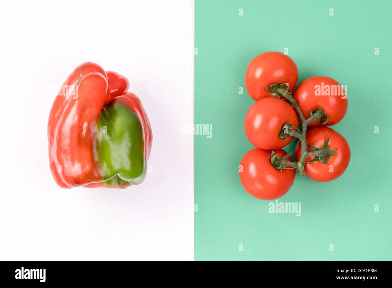 Mise en page créative au poivre et à la tomate sur fond vert et blanc coloré. Concept d'été minimal. Ingrédients pour la salade. Banque D'Images