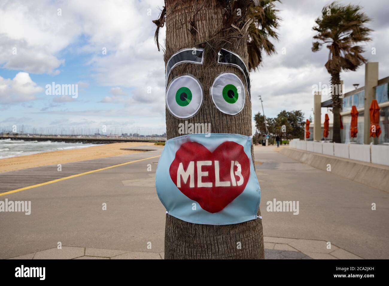 Melbourne Covid-19 2020. Masque « I love Melb » sur un arbre à une plage vide de St Kilda à Melbourne en Australie . Banque D'Images