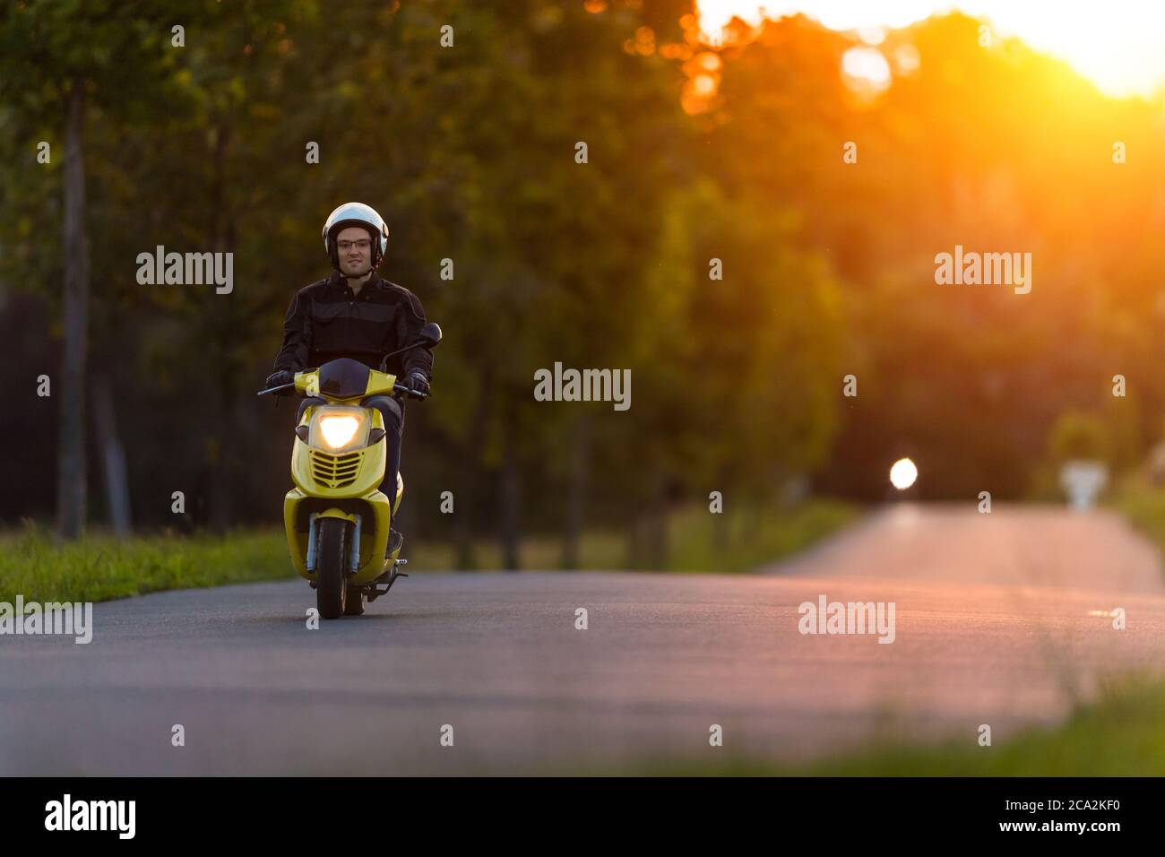 Moto sur route vide avec lumière du coucher de soleil, concept de vitesse  et de tourisme dans la nature. Petit scooter de moto Photo Stock - Alamy