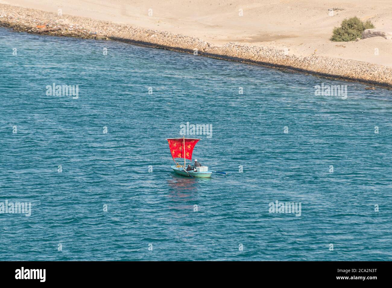 Ismailia, Egypte - 14 novembre 2019 : pêcheurs dans un bateau en bois sous une voile rouge le long du canal de Suez près d'Ismailia, Egypte, Afrique. Banque D'Images