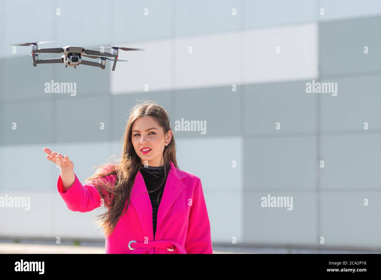 des terrains de drone sur la main, jeune femme défoqué en arrière-plan, se concentrent sur le quadricoptère Banque D'Images