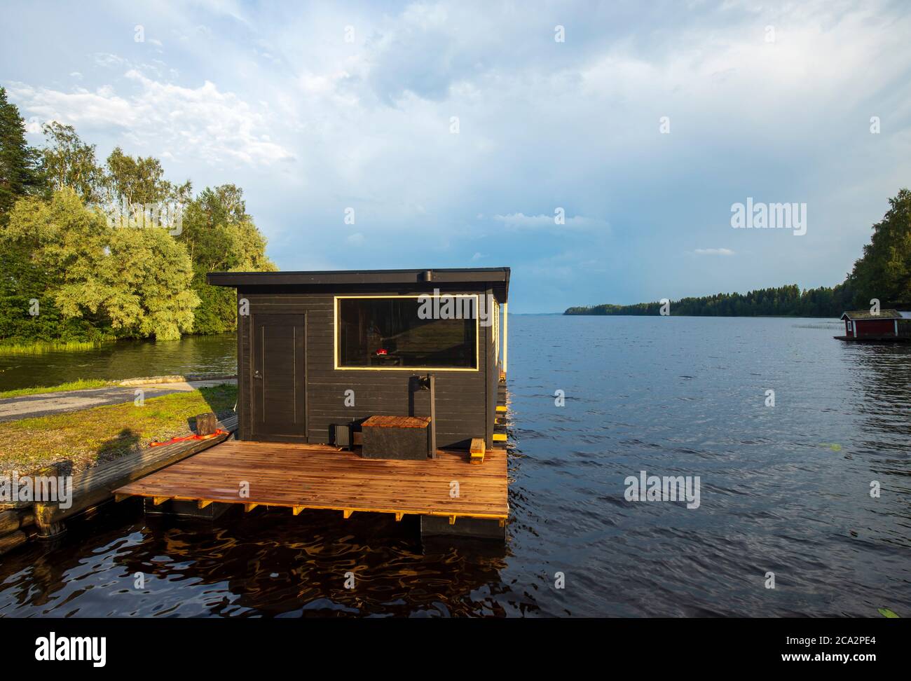 péniche flottante en bois brun avec sauna amarré à la jetée au lac Suontee à été, Finlande Banque D'Images