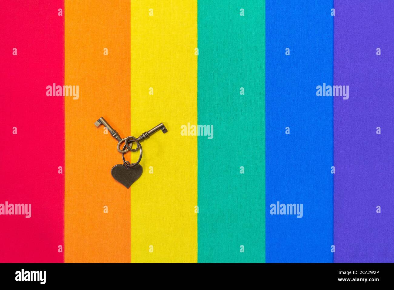 Coeur en métal et touches sur le motif de drapeau arc-en-ciel de la texture du tissu pour LGBTQ. Drapeau arc-en-ciel de la texture du tissu pour la fierté LGBT et les clés en métal et le coeur. Homo Banque D'Images