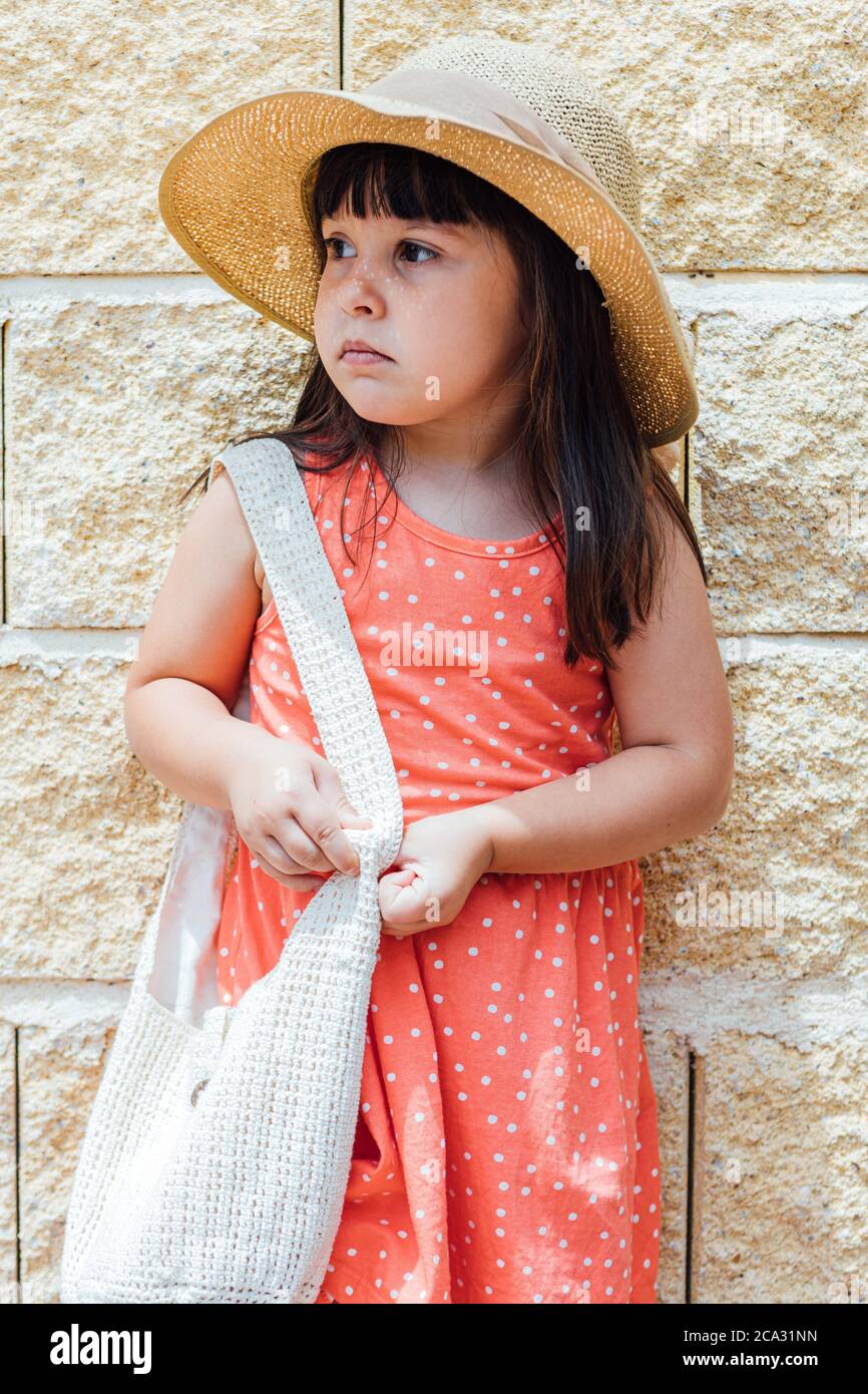 Portrait D Une Petite Fille A Cheveux Noirs Avec Robe D Ete Chapeau Et Sac Photo Stock Alamy