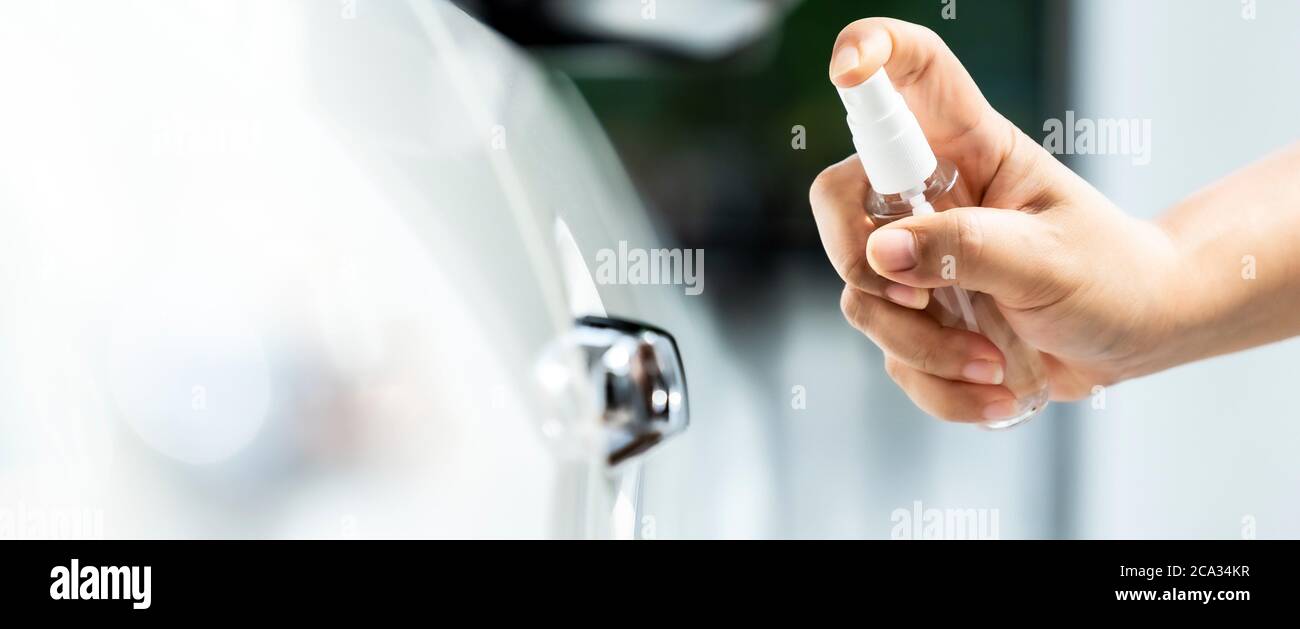 panoramique de la stérilisation de véhicule de voiture nettoyage à l'aide de l'alcool pulvérisé à la main, spray désinfectant sur la poignée de cdoor pour la sécurité prévenir protéger contre les virus Banque D'Images