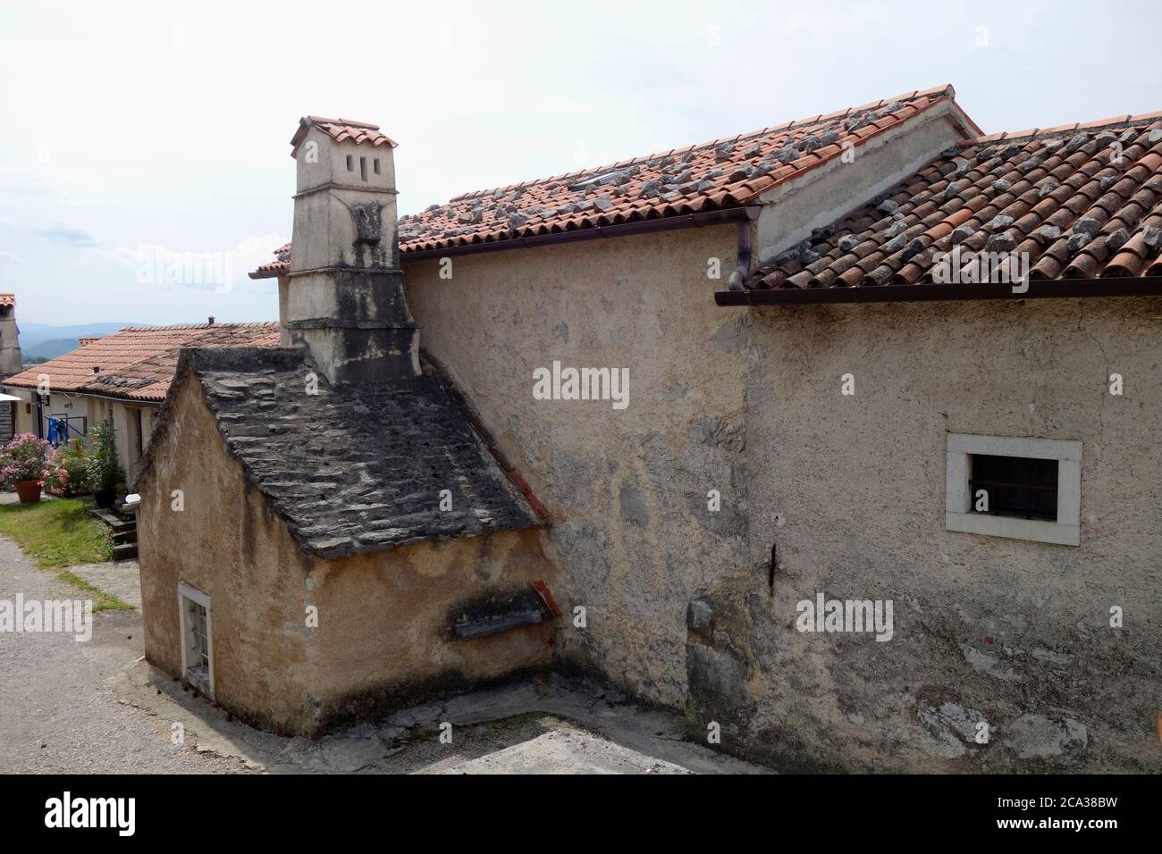 Architecture médiévale rurale. Maison de village avec cuisine médiévale (noire) extension externe. Village de Štanjel, municipalité de Komen, région de Kras, Sloveni Banque D'Images