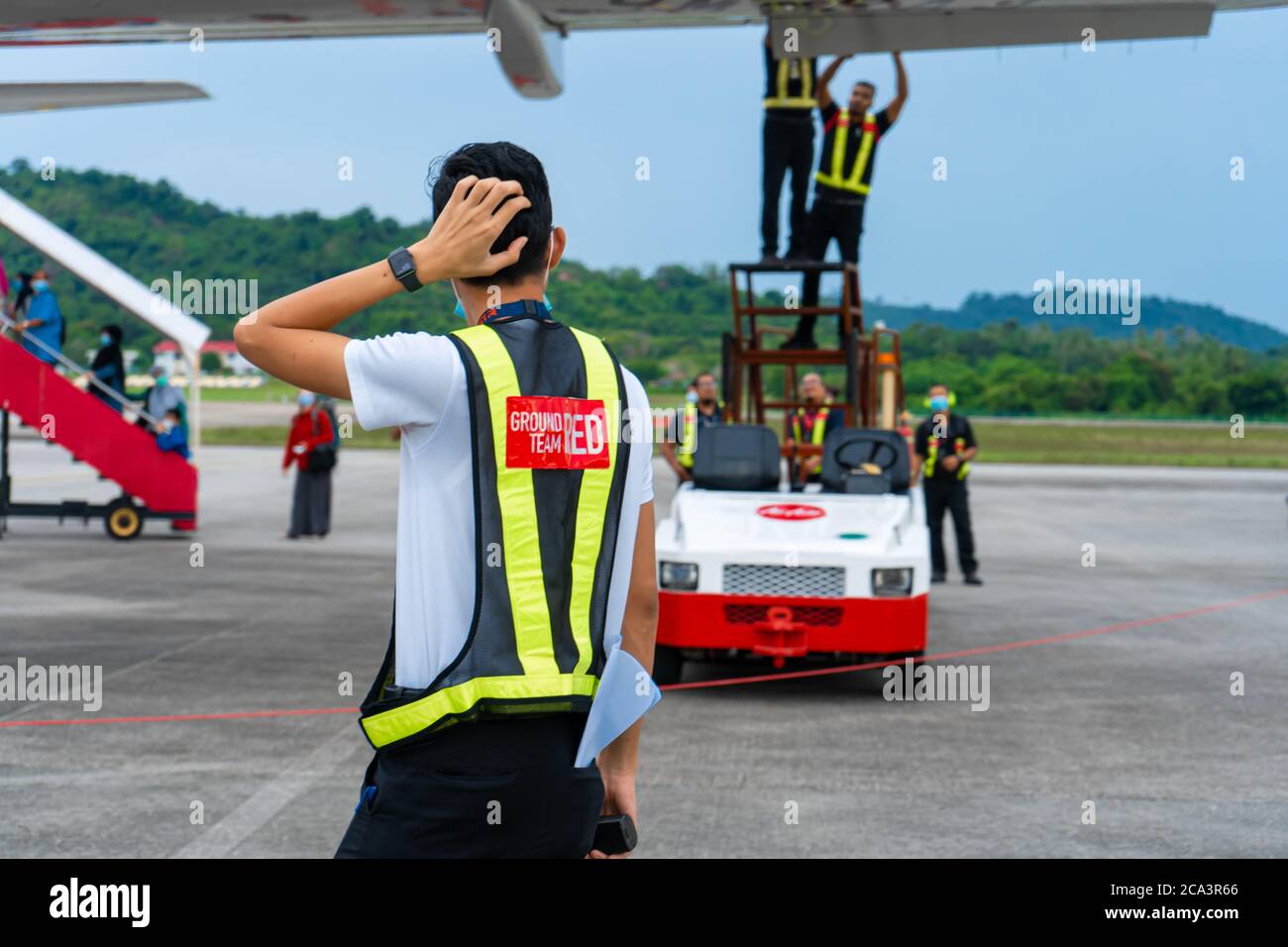 Un technicien en avionique observe la confusion pendant que l'équipe de techniciens d'aéroport dépanne et répare un volet sur un avion passager avant le départ. Air de champ Banque D'Images