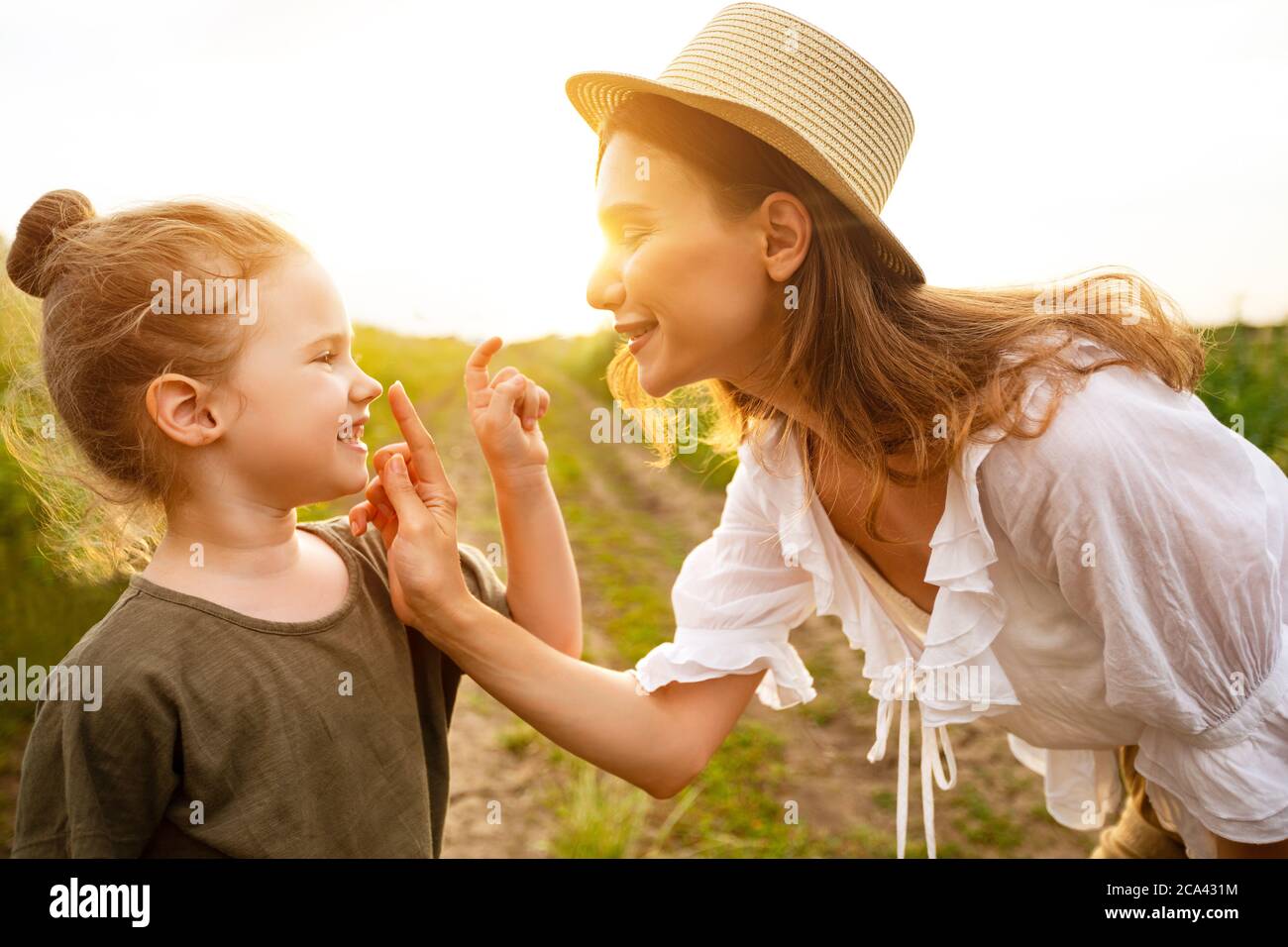 Bonne maman et bébé jouant ensemble dans le champ de printemps Banque D'Images