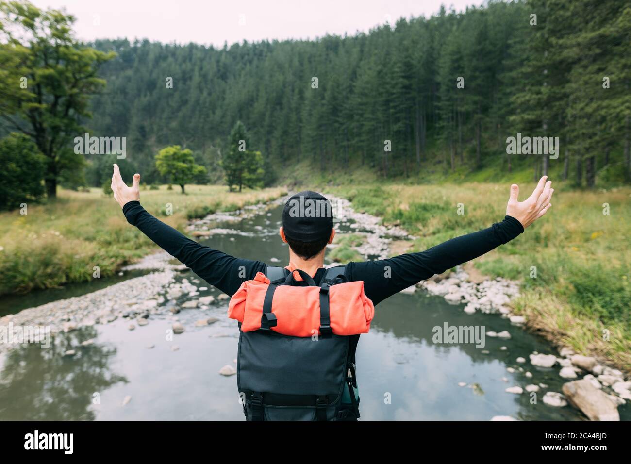 Jeune homme explorateur de la nature appréciant la vue sur la rivière dans la nature Banque D'Images