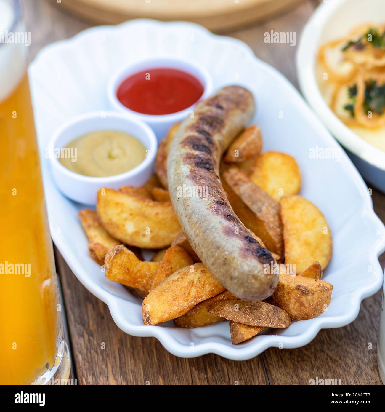 Saucisse allemande avec pommes de terre frites, ketchup gros plan Banque D'Images