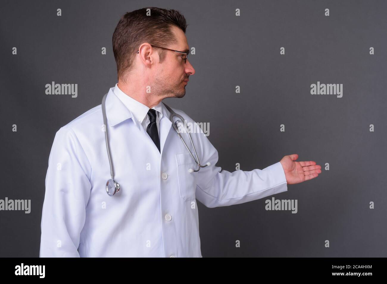Portrait de beau barbu homme médecin sur fond gris Banque D'Images