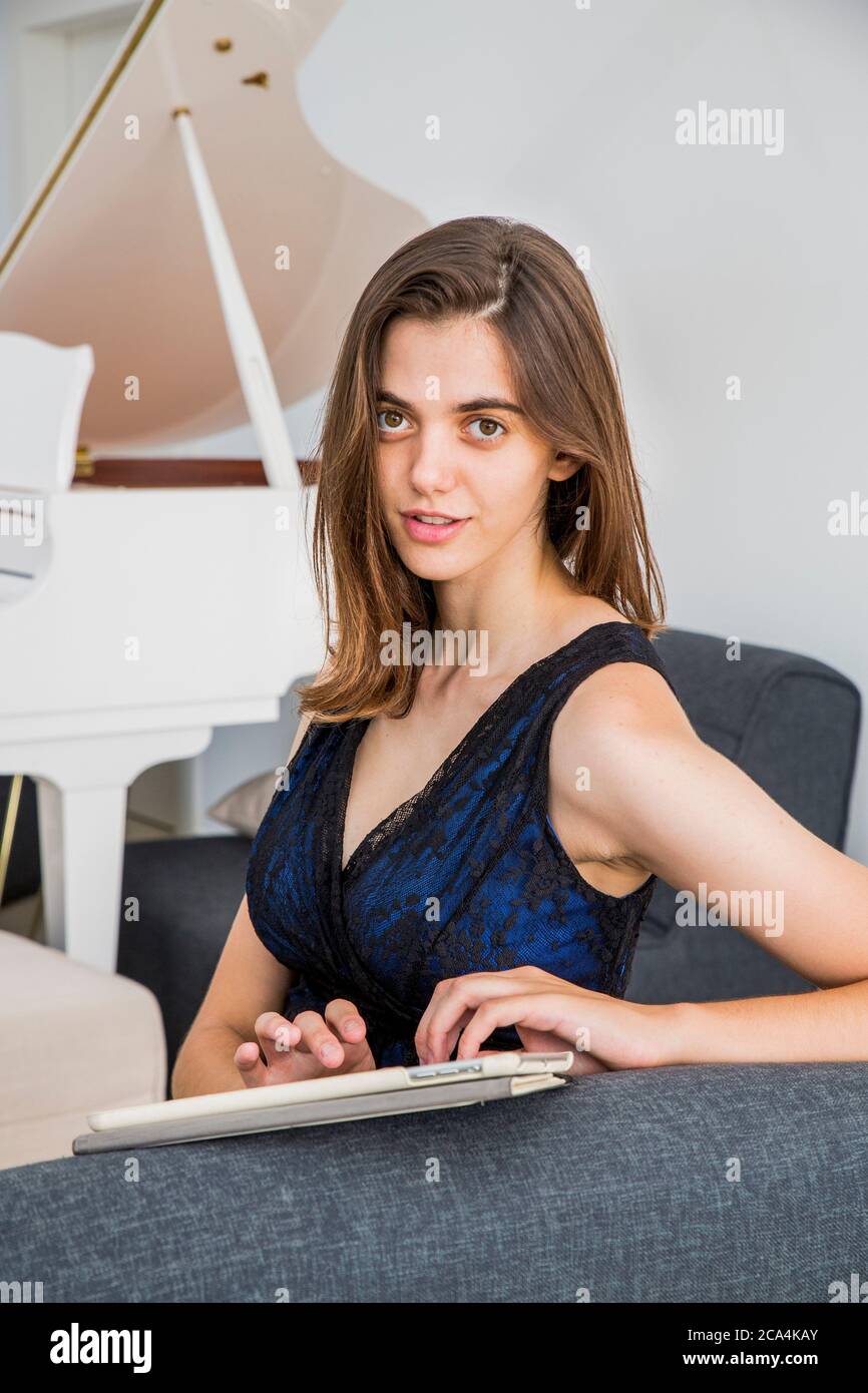 Jeune femme en robe de soirée travaille de la maison sur un pavé tactile Banque D'Images