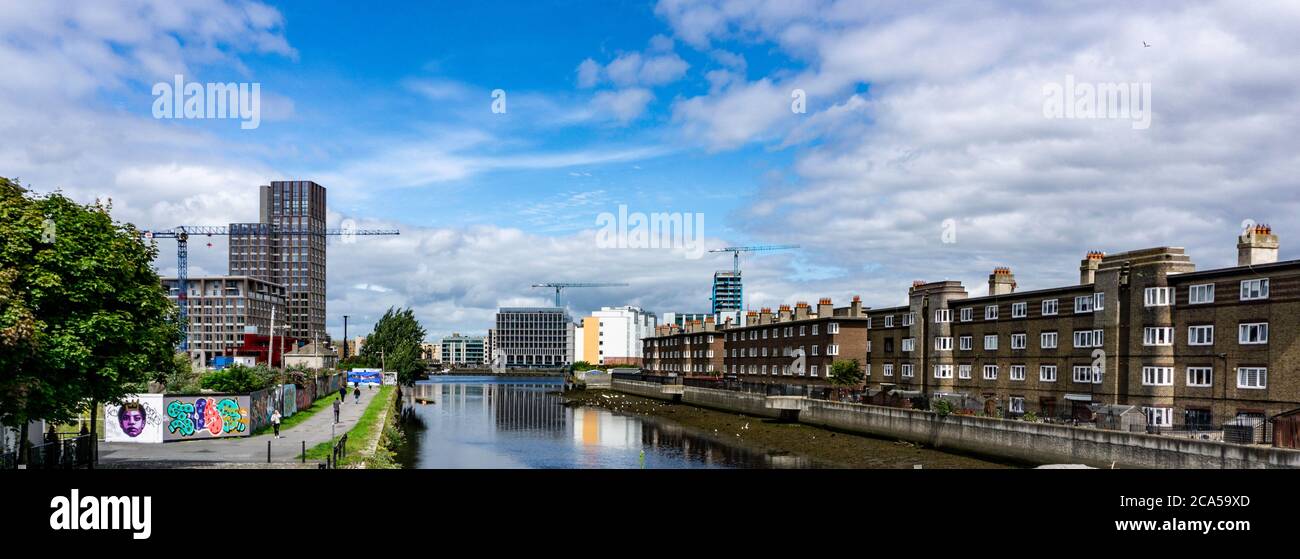 L'ancien logement public de Ringsend à droite de la photo est séparé par la rivière Dsurder des développements modernes du Grand Canal à Dublin. Banque D'Images