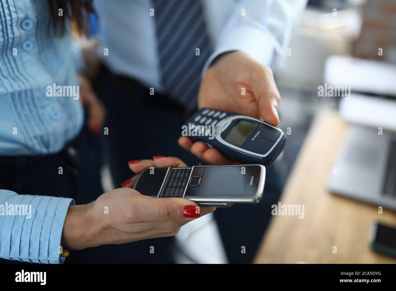 Homme d'affaires et femme d'affaires Hol bouton vintsge téléphone nokia Banque D'Images