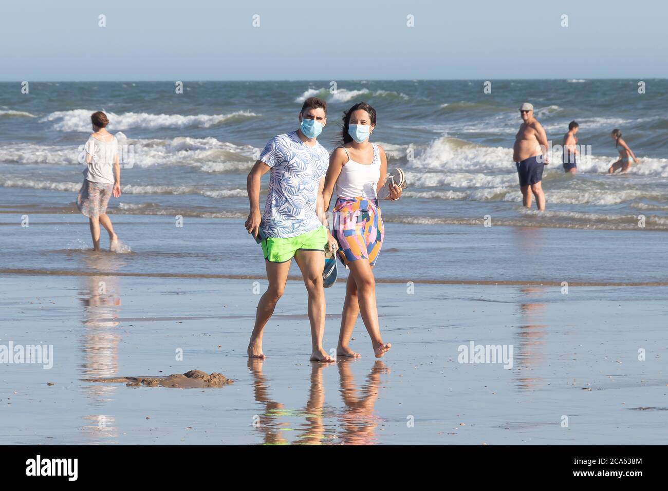 Punta Umbria, Huelva, Espagne - 2 août 2020 : couple marchant sur la plage avec des masques protecteurs ou médicaux. Nouvelle normale en Espagne avec di social Banque D'Images
