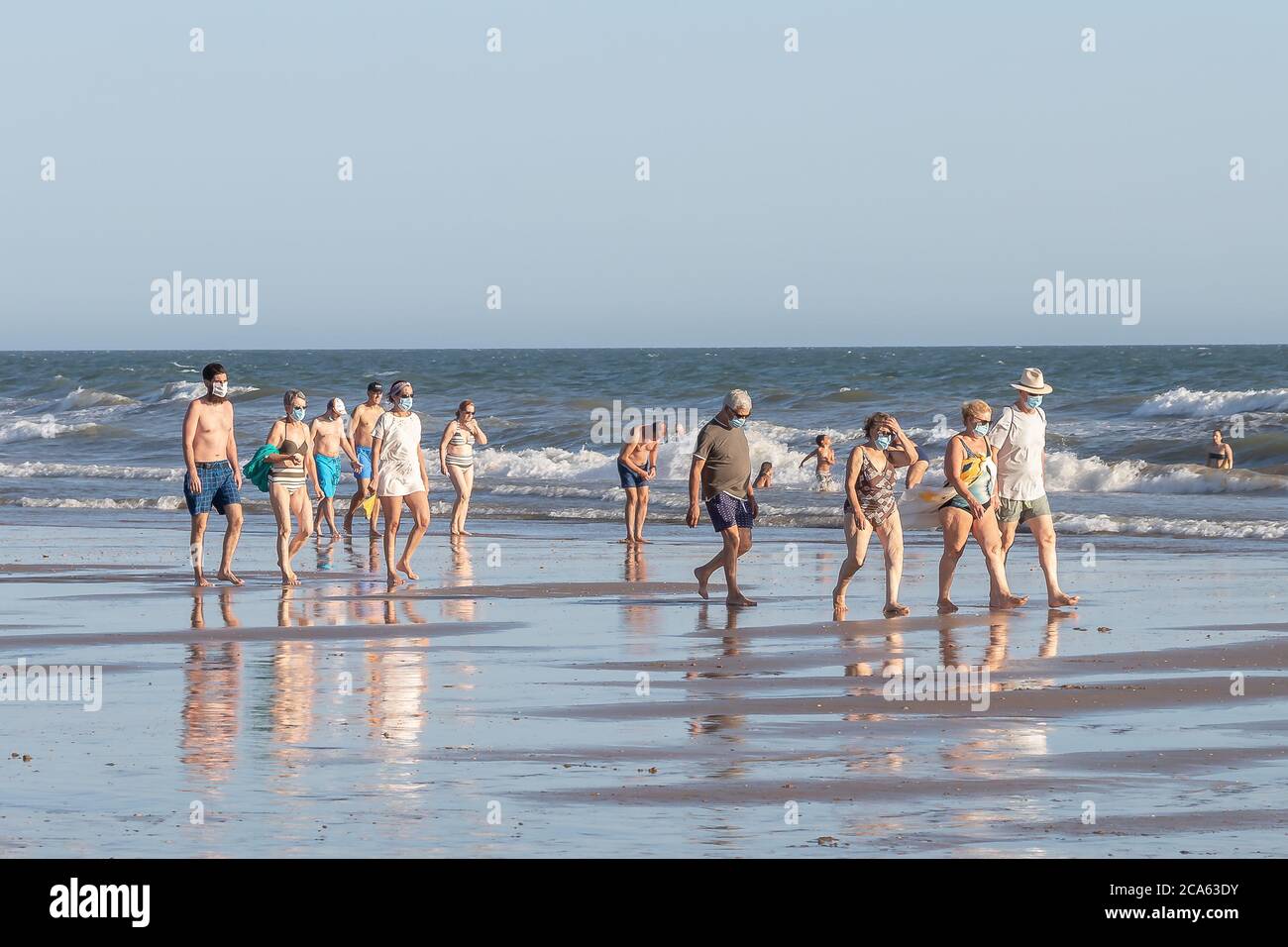 Punta Umbria, Huelva, Espagne - 2 août 2020: Beaucoup de personnes marchant sur la plage portant des masques protecteurs ou médicaux. Nouvelle norme en Espagne avec Banque D'Images