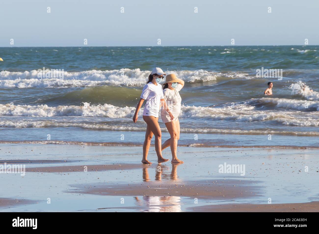 Punta Umbria, Huelva, Espagne - 2 août 2020 : deux femmes marchant sur la plage portant des masques protecteurs ou médicaux. Nouvelle normale en Espagne avec social Banque D'Images