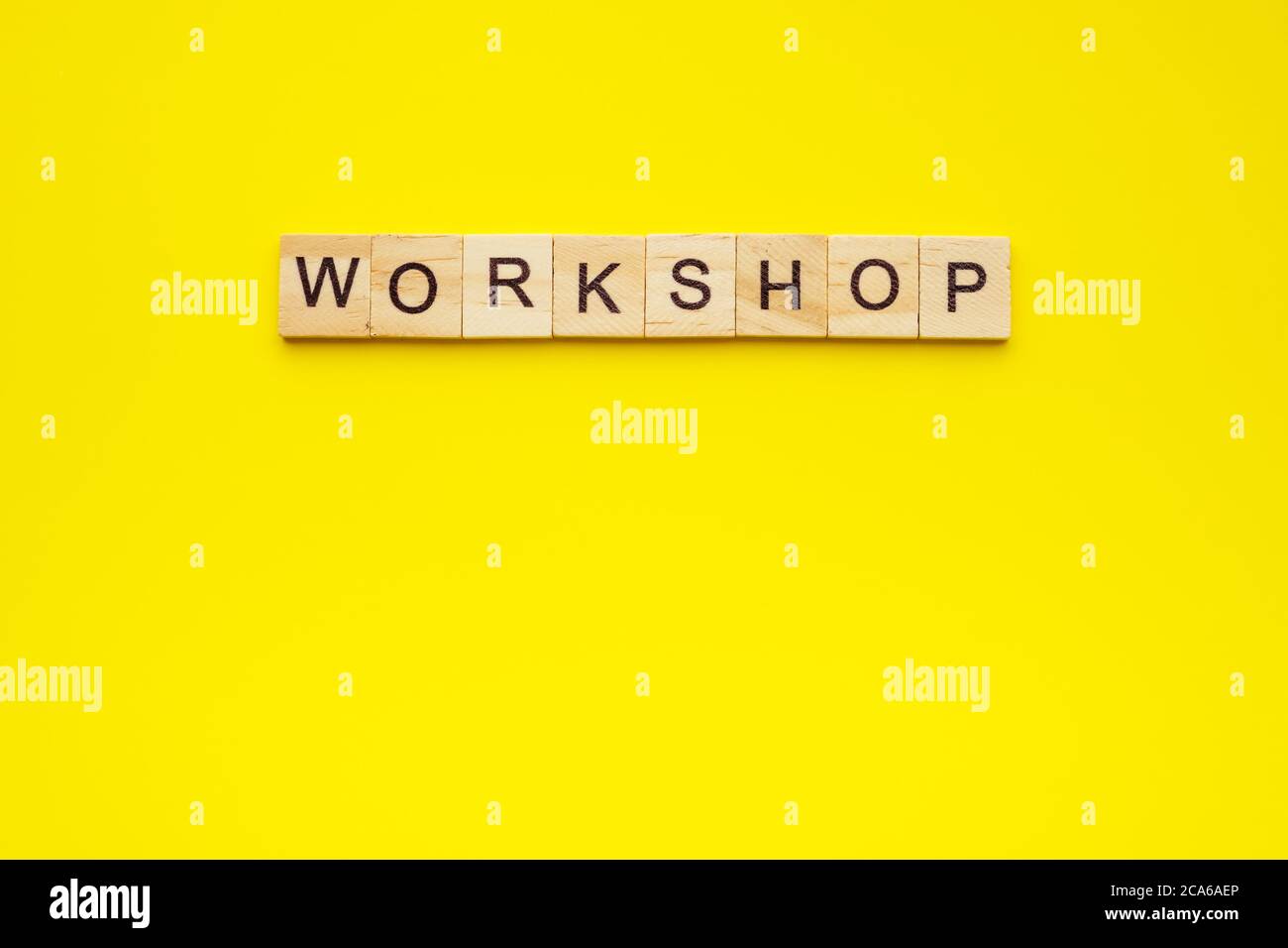 atelier de texte fait avec des lettres en bois sur fond jaune. Banque D'Images