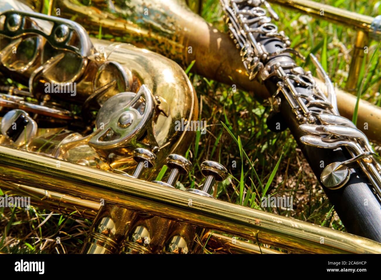 Des instruments de musique, dont la clarinette en trompette trombone et le saxophone, se trouvent dans un champ herbacé au festival de musique Banque D'Images