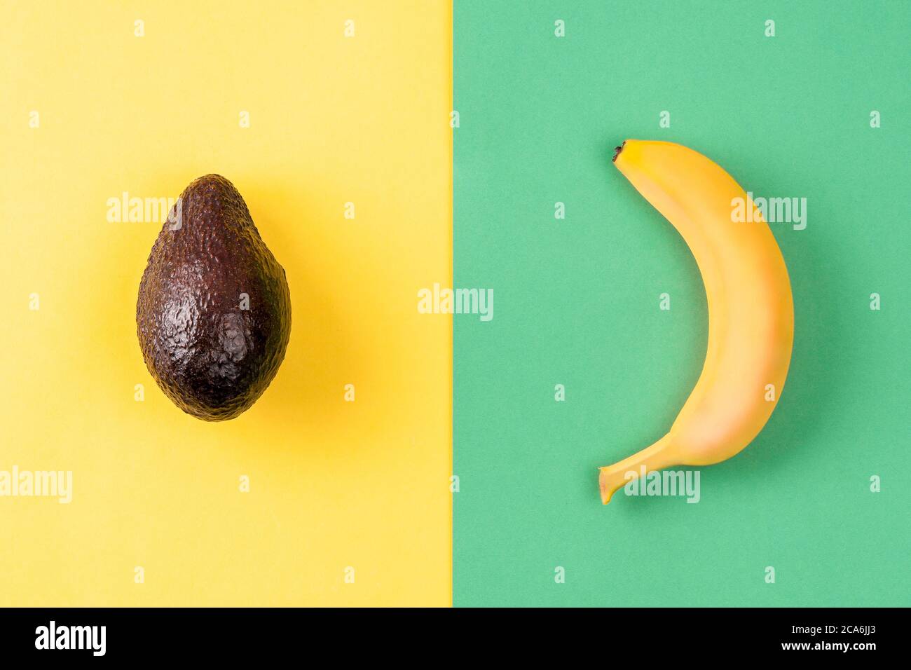 Mise en page créative faite de banane et d'avocat sur fond coloré. Concept d'été minimal. Motif fruits. Banque D'Images