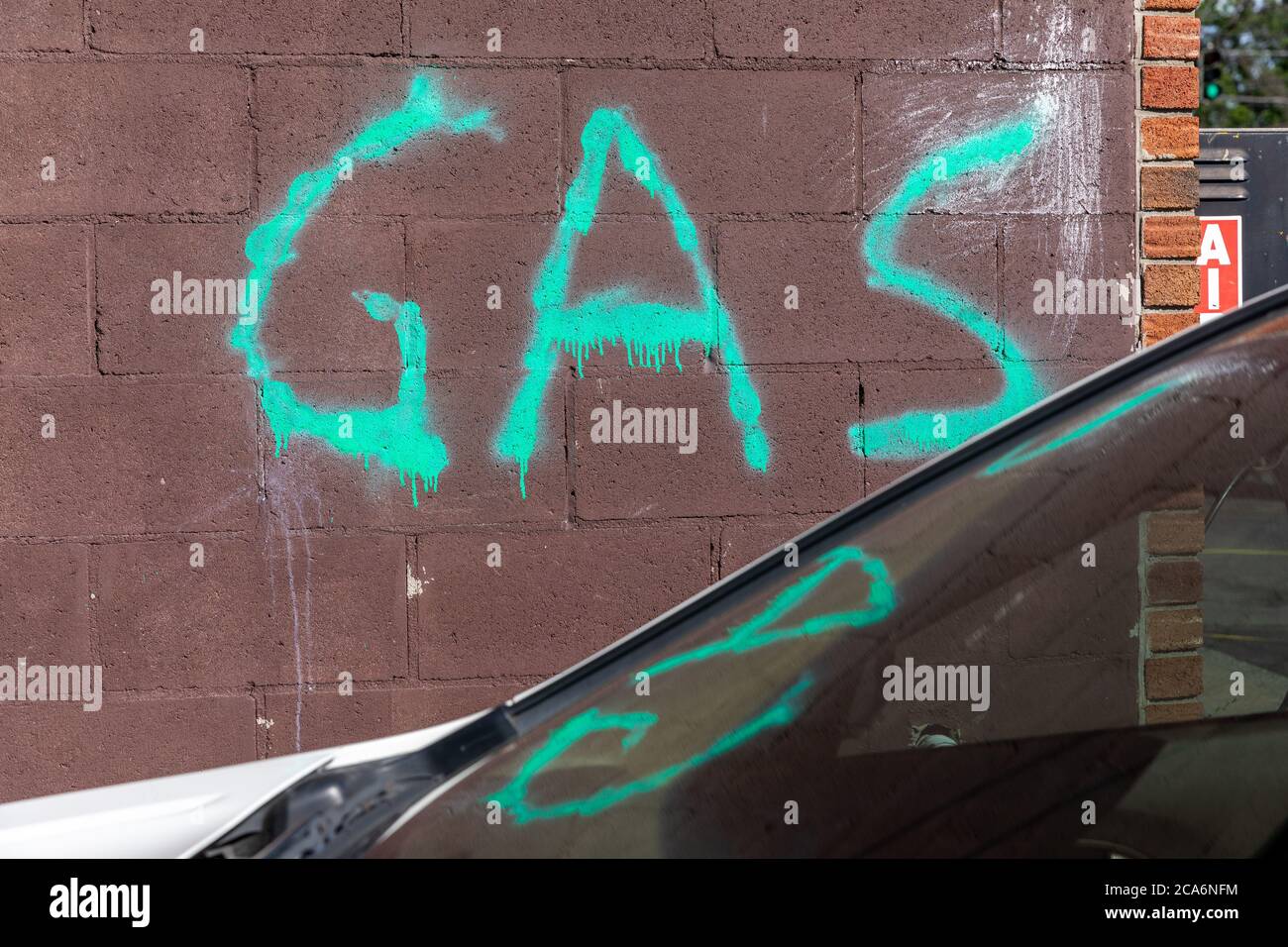 Signe brut dans la peinture verte en spray annonçant l'essence, alias « gaz ». Banque D'Images