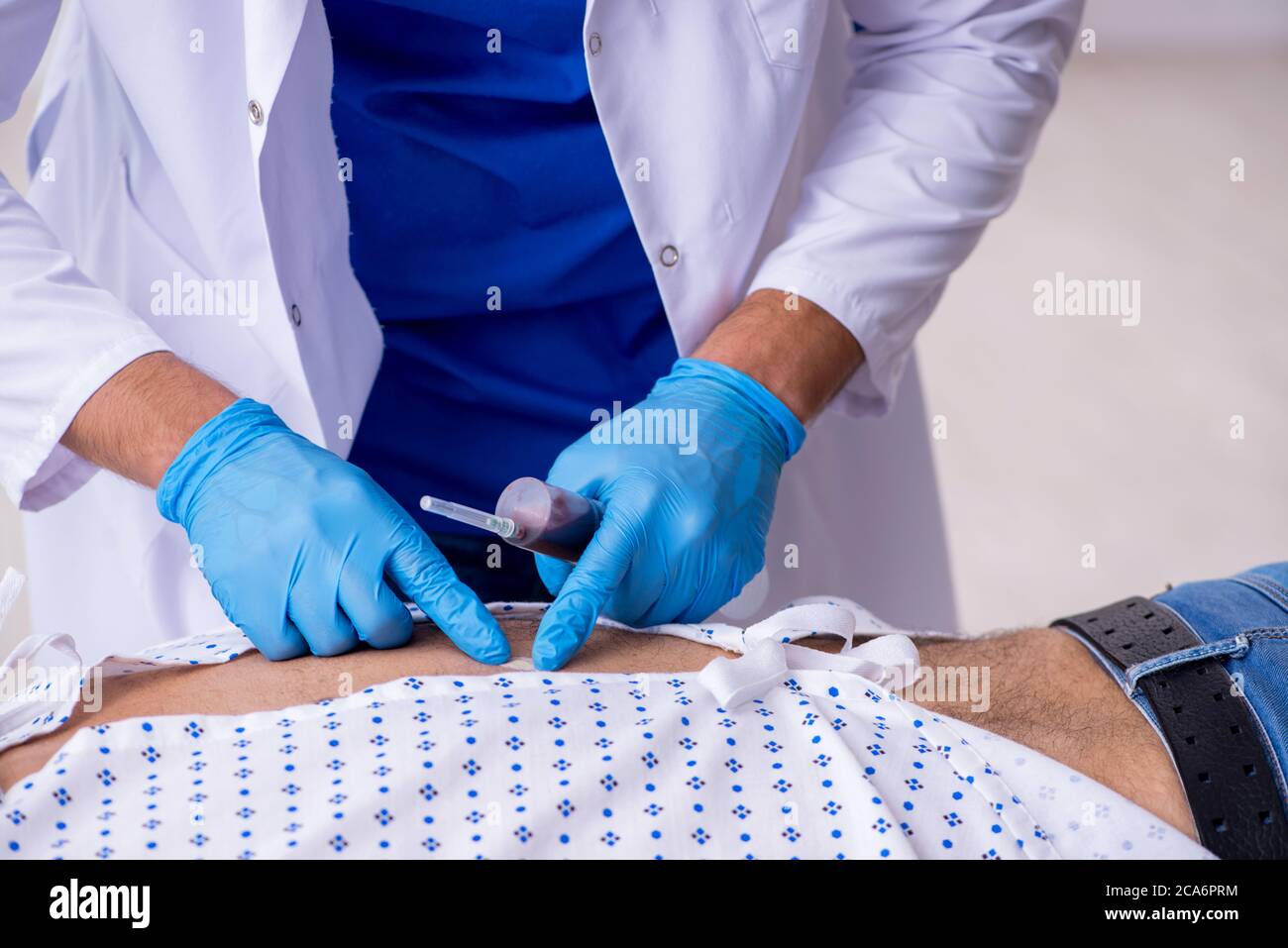 Un vieil homme qui rend visite à un jeune médecin stagiaire Banque D'Images