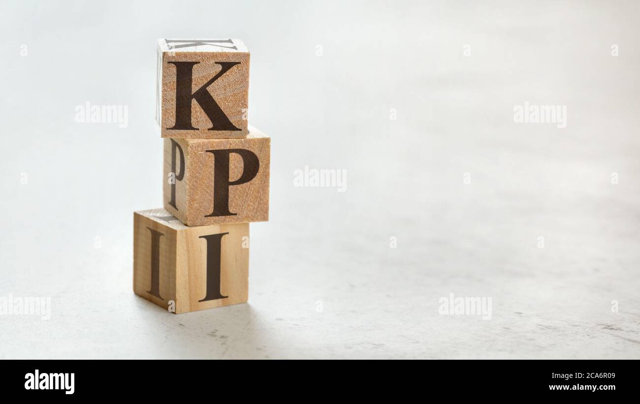 Pile avec trois cubes en bois - lettres KPI signifiant indicateur de performance clé sur eux, espace pour plus de texte / images sur le côté droit. Banque D'Images
