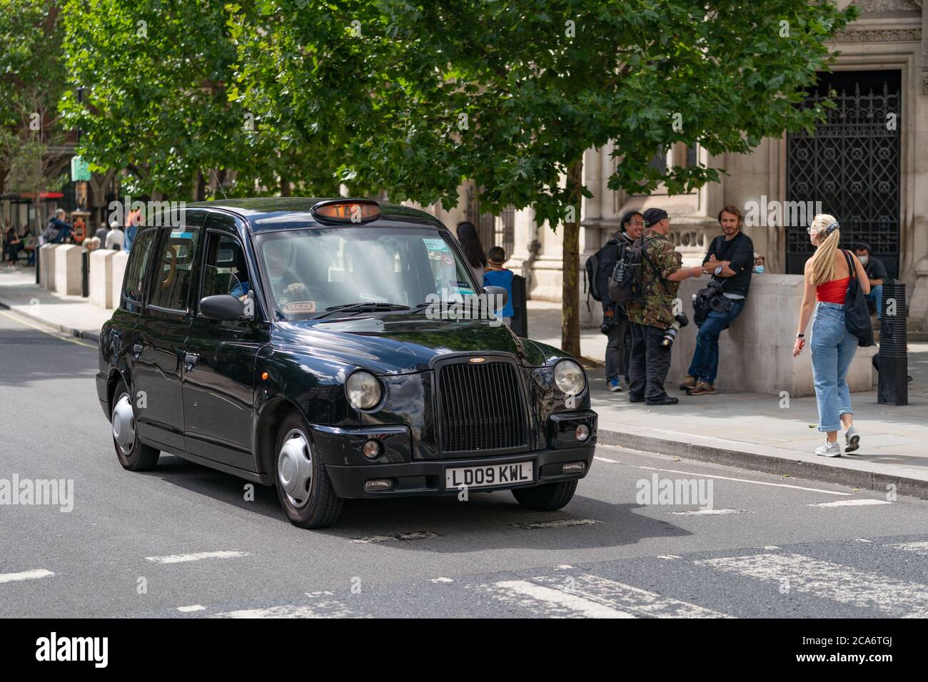 LONDRES, ANGLETERRE - 28 JUILLET 2020 : taxi noir traditionnel de Londres devant les cours royales de justice pendant le procès de Johnny Depp avec les Paparazzi Banque D'Images