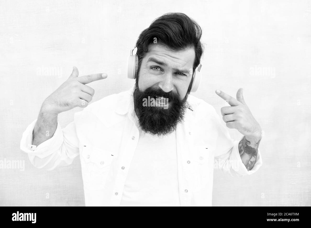 Technologie d'annulation active du bruit. Hipster écoute des écouteurs stéréo. Casque sans fil moderne. Pistes de musique de danse électroniques. Musique instrumentale. Casque homme barbu. Profitez de chaque note. Banque D'Images