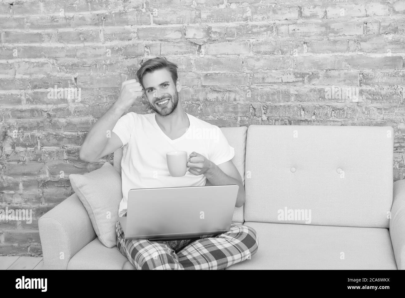 L'éducation à distance. Heureux homme sur canapé. guy appréciant l'Internet. La dépendance aux médias sociaux. Ordinateur acct. flirt et envoyer un message texte. Style de vie domestique avec abus mobile. Beau homme en ligne datant. Banque D'Images